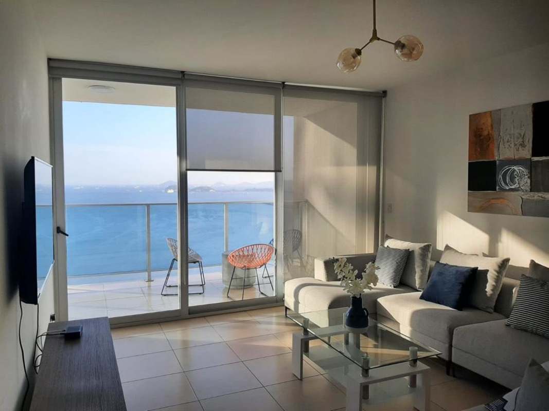 Living room with contemporary furnishings overlooking ocean balcony PH BICSA Panama City