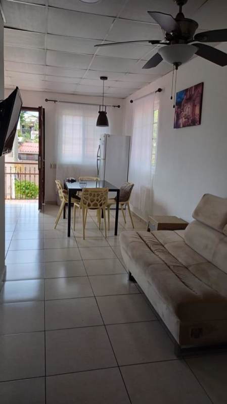 Open plan living dining area with light tile, sofa, view to balcony in Villa Lucre Panama rental