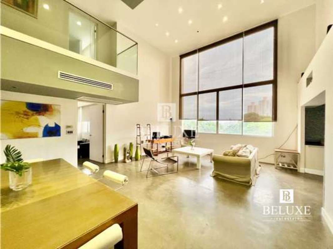 Modern dining space with mezzanine loft and balcony overlooking Panama City in PH Portanova, El Cangrejo