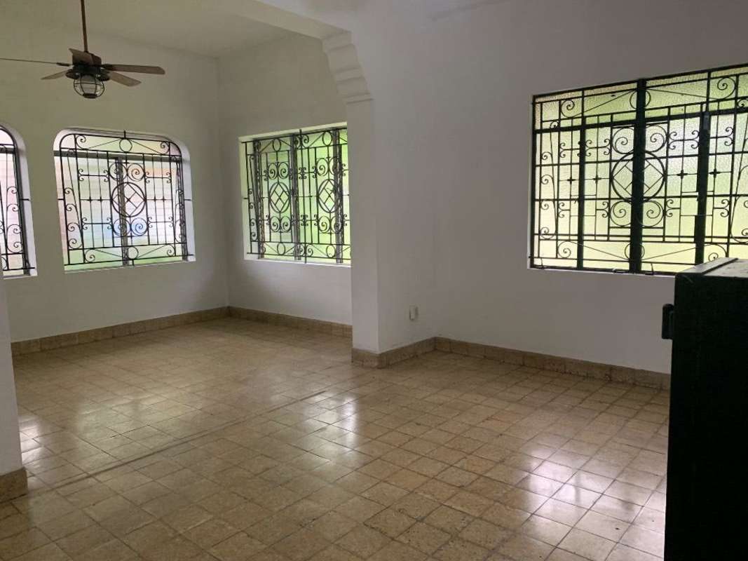 Living room with windows, wrought iron grills and tiled floor in Casa Roja Bella Vista