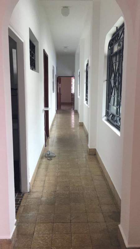 Elongated hallway with multiple windows, tiled floor and arched entry in Casa Roja Bella Vista