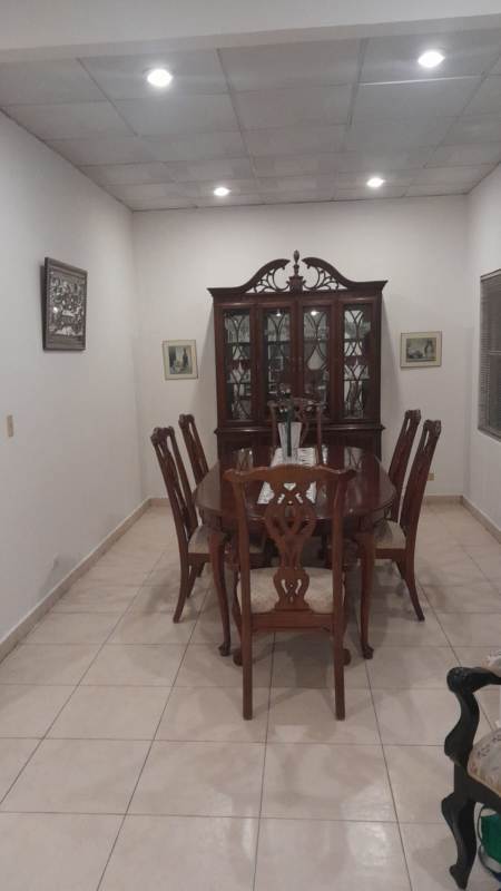 Dining room with wooden table and china cabinet in spacious Ancón Panama rental home