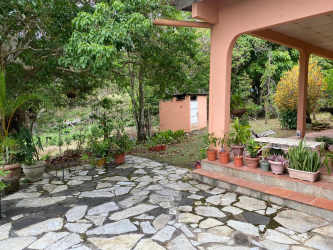 Rustic country home with covered patio surrounded by greenery Sora Chame Panama