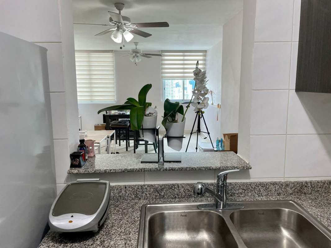 Kitchen serving window looking into open dining and living area in PH Vivendi Towers Edison Park Panama