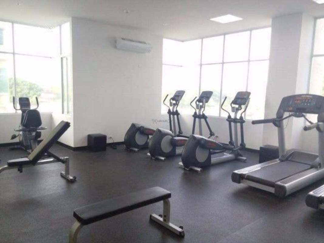 Modern fitness room with cardio machines and large windows at PH Vivendi Towers Edison Park Panama