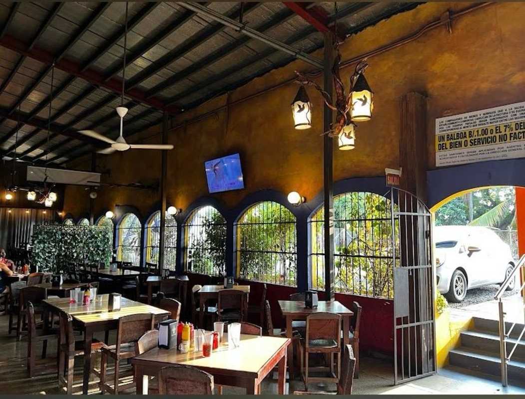 Rustic restaurant dining area wood décor ceiling fans arched windows Juan Díaz Panama