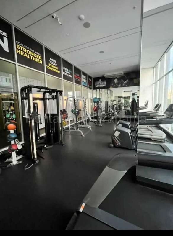 Fitness center with cardio machines large windows overlooking Panama City in PH Vista Loft Panama