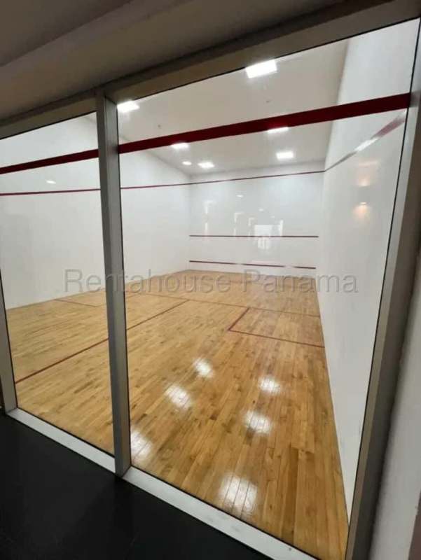 Modern squash court with wooden flooring and glass wall at PH Vista Loft tower Panama City