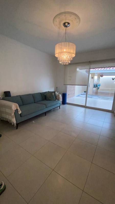 Spacious living room with chandelier and outdoor access in Villa Tivoli Brisas del Golf Panama