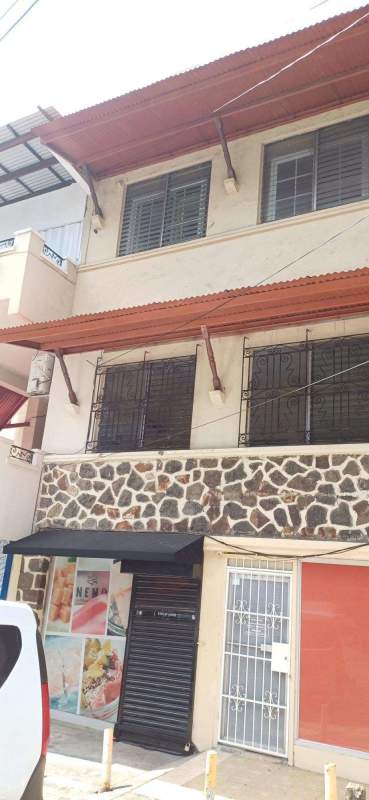 Two-story mixed-use building with stone facade and glass storefront in Bella Vista Panama