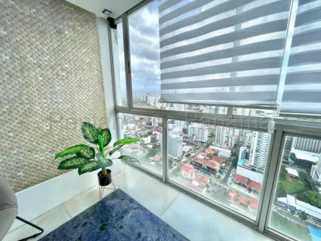 Open plan furnished dining and living with city skyline PH Acqua San Francisco Panama