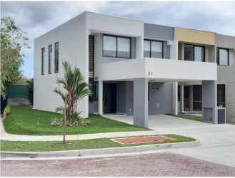 Front view of new modern two-story home with large windows, balcony, covered parking at Alere Panama Pacifico