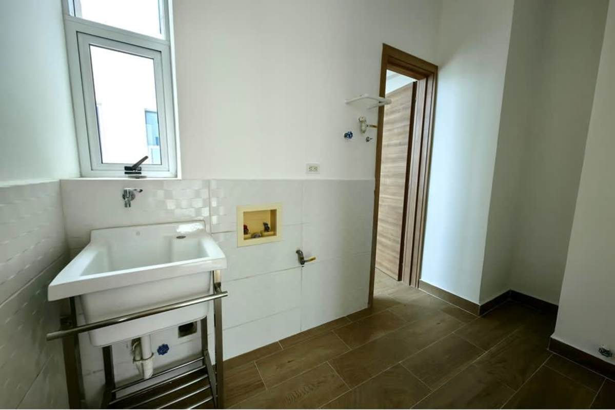 Dedicated laundry space with stainless sink, tiled walls in luxury penthouse