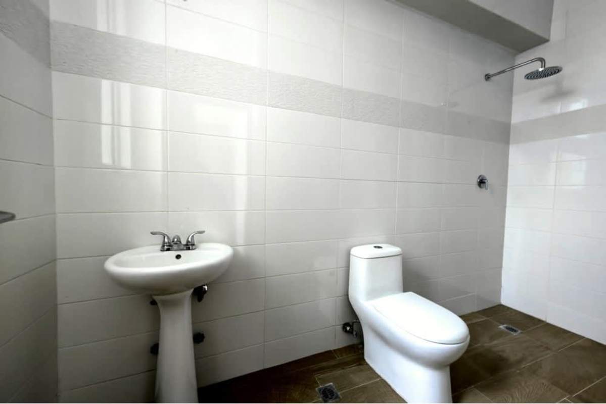 Stylish bathroom with walk-in shower and pedestal sink in PH Bella Vista Manhattan