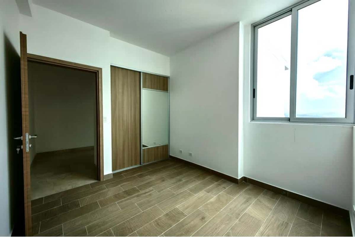 Bright bedroom with large window, mirrored built-in wardrobe in Bella Vista penthouse