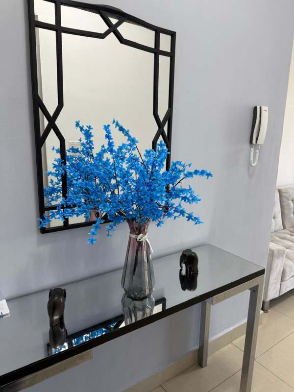 Entryway with console table, geometric mirror, flowers, intercom in Panama apartment rental