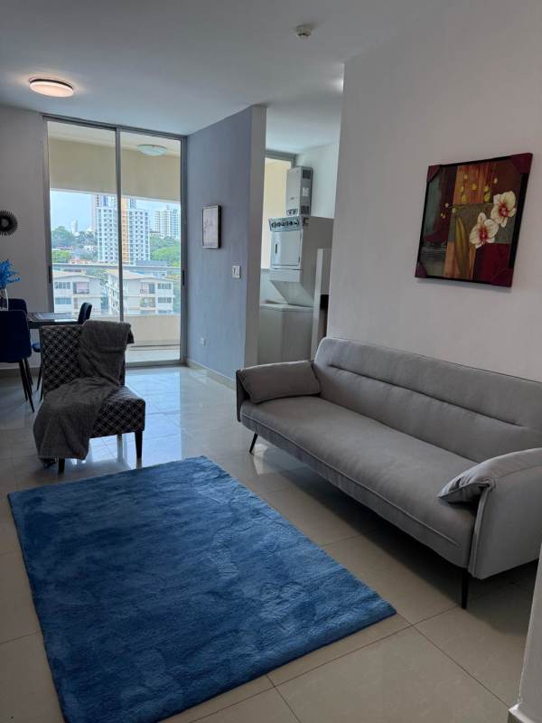 Living area with sliding doors to balcony, city skyline, dining set in Panama furnished rental