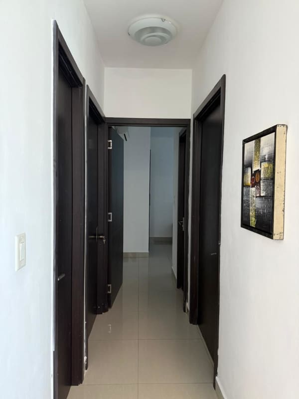 Modern hallway featuring dark doors, tile floor, wall art in PH San Francisco Bay apartment rental