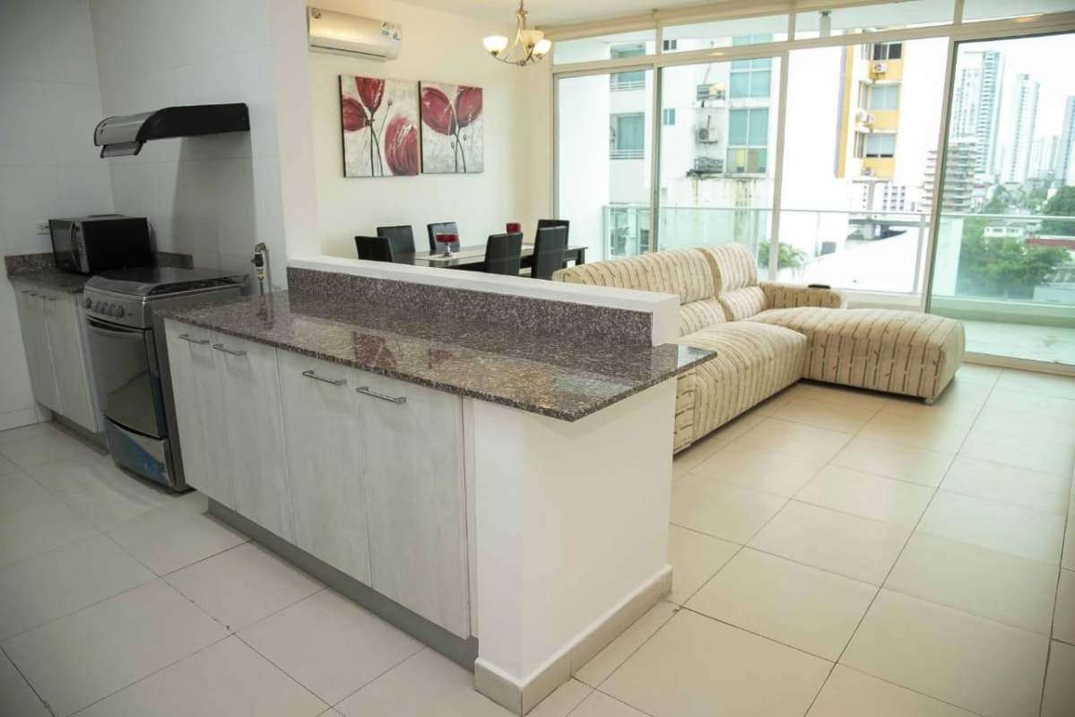 Bright open living and dining area with granite kitchen and floor-to-ceiling windows overlooking Panama City