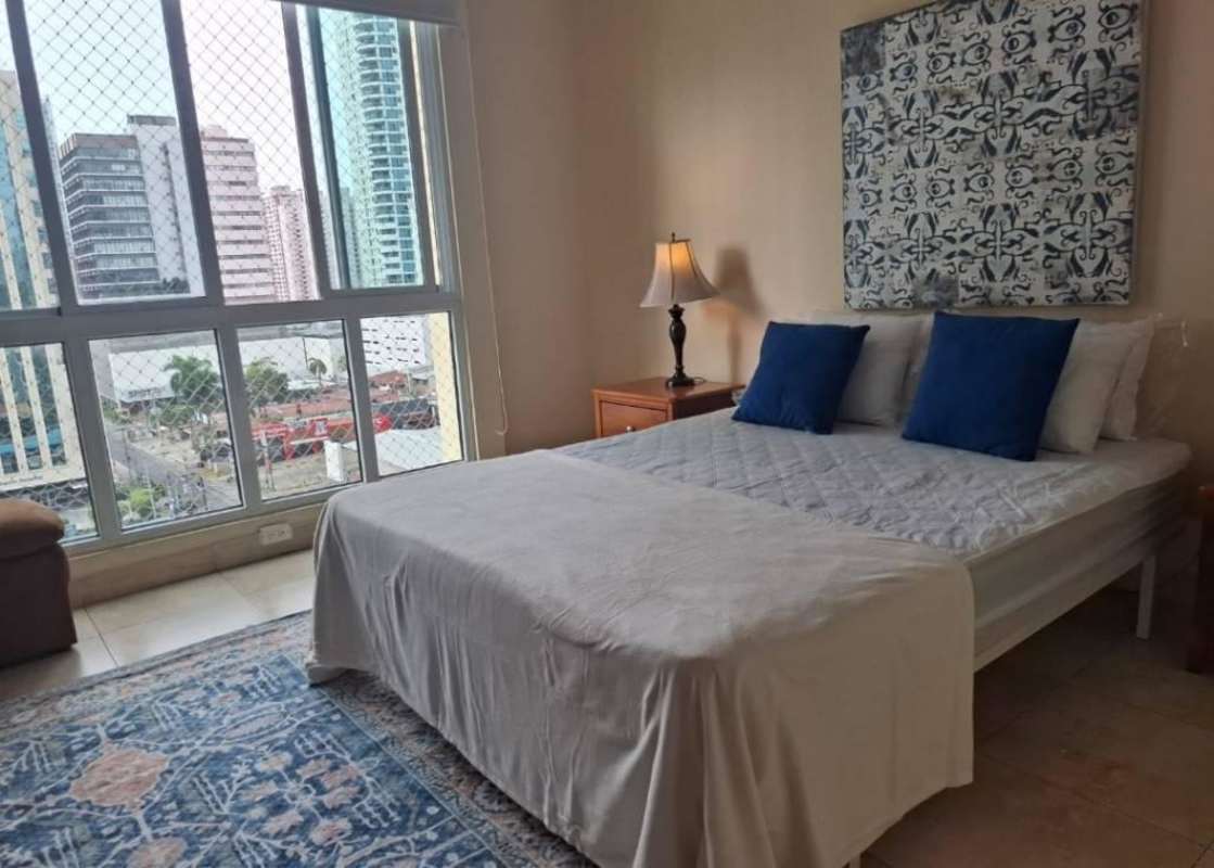 Double bed with blue pillows, wall art, bedside tables in PH San Francisco Bay Panama