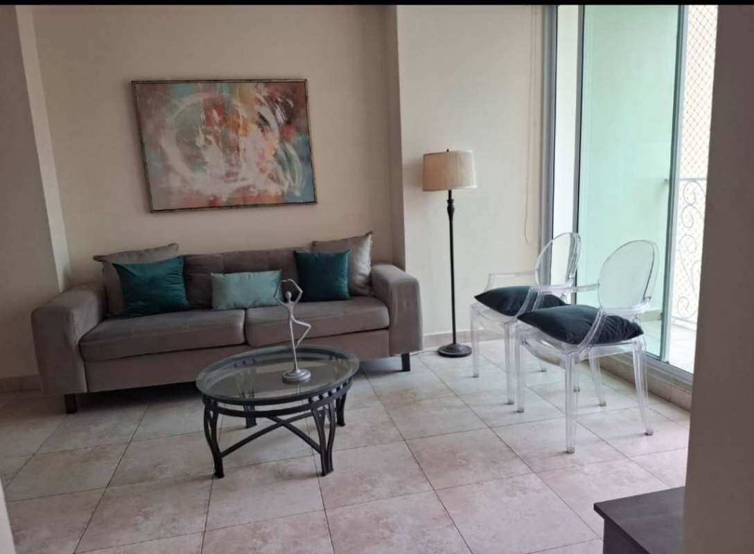 Modern living room with sliding doors to balcony, gray sofa, glass table at PH San Francisco Bay