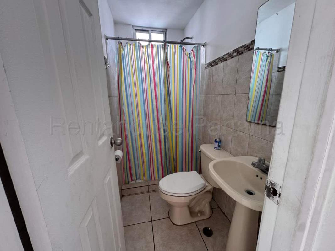 Bathroom with beige tiles, mirror, pink shower curtain PH Sunshine Panama