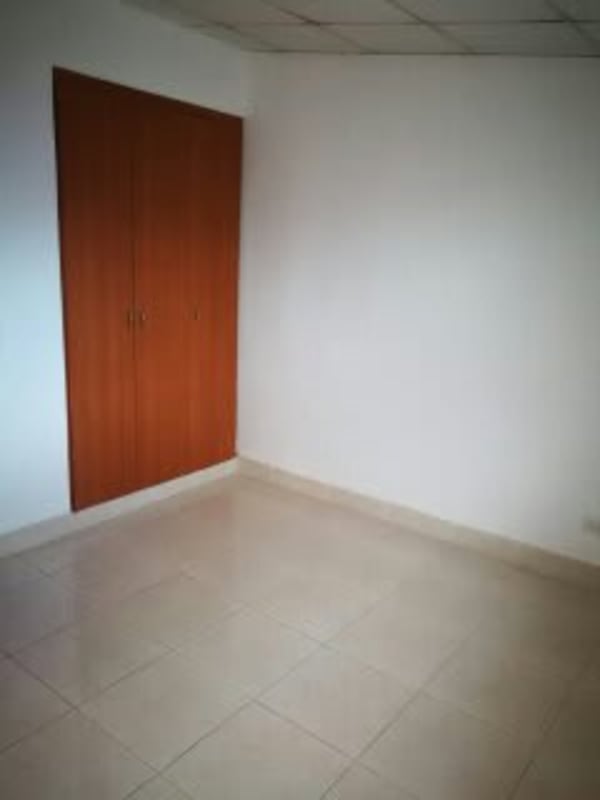 Bedroom with window security bars and tiled floor in Panama rental house.