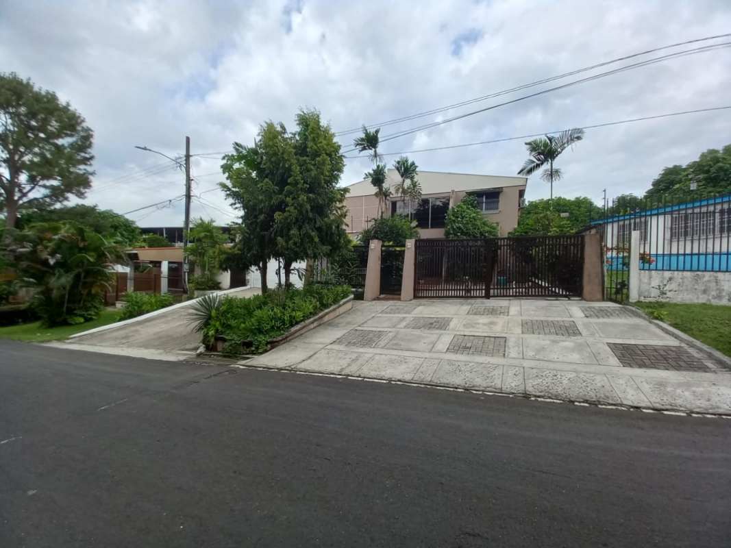 Landscaped courtyard patio with lush tropical plants and arched balcony at Las Cumbres house Panama