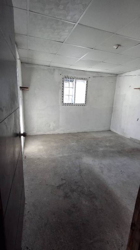 Simple room with tiled ceiling, barred window and tiled floor in Las Acacias Panama house ready to remodel