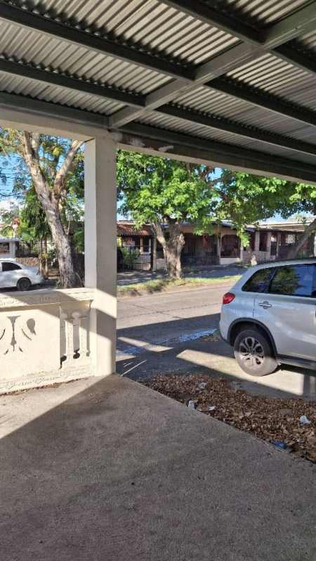 Covered porch with parking and street view at Las Acacias house for sale.