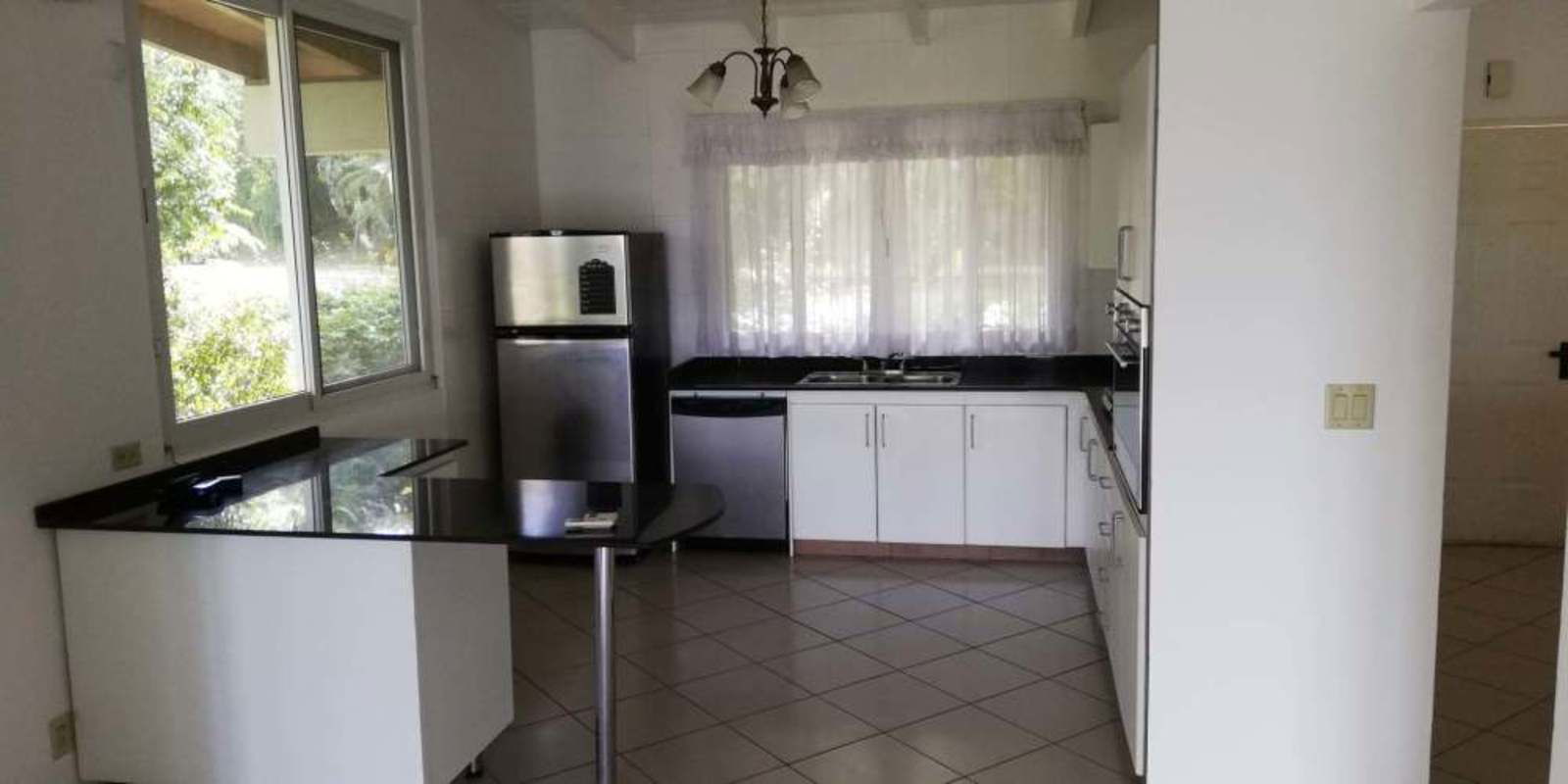 Covered terrace with tiled floor facing lush garden and forest Ancón Panama