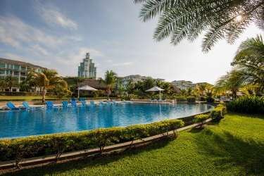 Large swimming pool surrounded by palm trees and tropical landscaping in Bijao Beach Panama