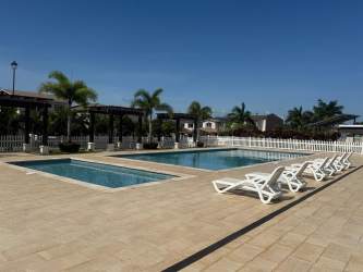 Outdoor pool with lounge chairs palm trees pergolas Costa Verde New West Panama