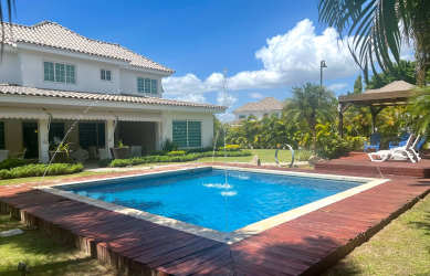 Front facade two-story beach house with tiled roof and manicured garden in Bijao Miraflores
