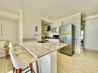 Granite kitchen open to bright living space in Playa Caracol Punta Chame Condo