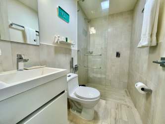 Contemporary bathroom with walk-in glass shower in Playa Caracol condo Panama