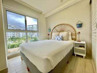 Bright master bedroom with ocean views, large window, ceiling fan at Playa Caracol Punta Chame