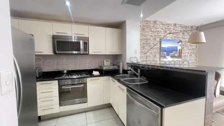 Balcony with hammock and seating overlooking pool area in PH Midrise Panama Pacifico