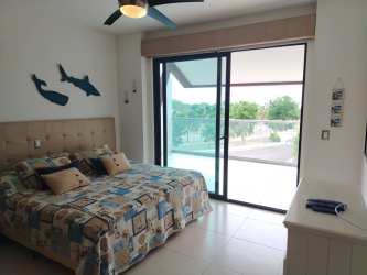 Secondary bedroom with large windows and garden view CasaMar beachfront apartment Panama