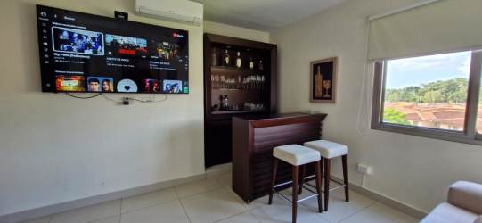 Bright living room with bar, AC, and TV in furnished apartment Panama Pacifico