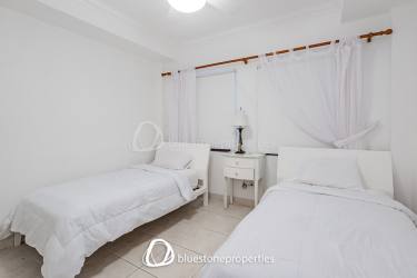 Minimalist twin bedroom with two beds, tile floors and AC at Playa Blanca beach villa Panamá