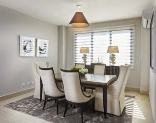 Dining room with upholstered chairs, art, and large window in PH River Valley condo Panama