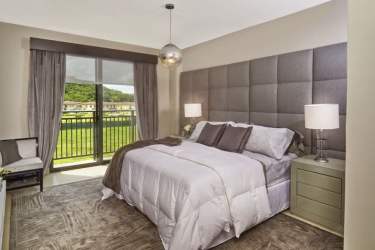 Stylish primary bedroom with padded headboard, glass doors to terrace at PH River Valley