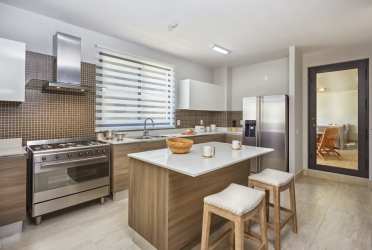 Bedroom with large padded headboard, sliding balcony doors with views in PH River Valley Panama