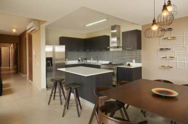 Contemporary kitchen with quartz countertops, island, and stainless appliances at PH River Valley