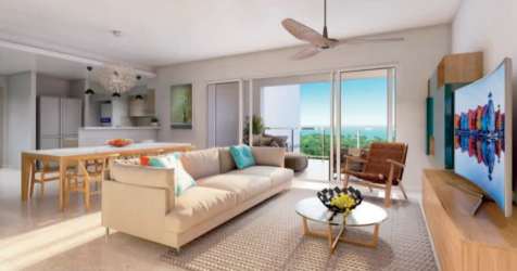 Modern living room with sliding glass doors to terrace overlooking ocean and golf course at Bijao Beach Club Panama