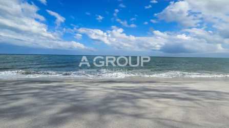 Gated entrance with pillars surrounded by tropical landscaping at Playa Coronado