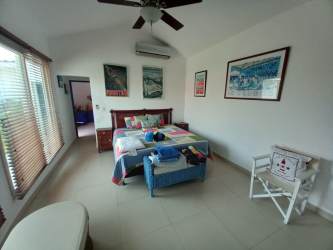 Covered outdoor terrace with arches ceiling fans overlooking pool in Punta Barco Village home