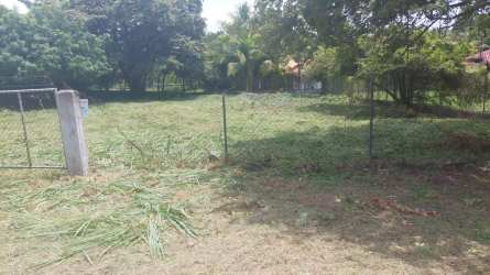 Empty titled land plot with wire fencing along quiet street Playa Coronado Panama
