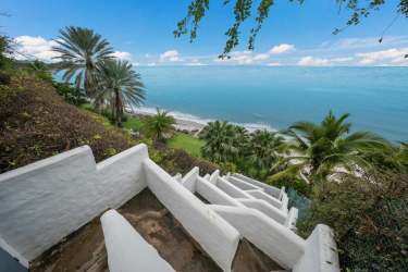 White stucco stairs under palms leading to private tropical beach at Punta Roca Panama